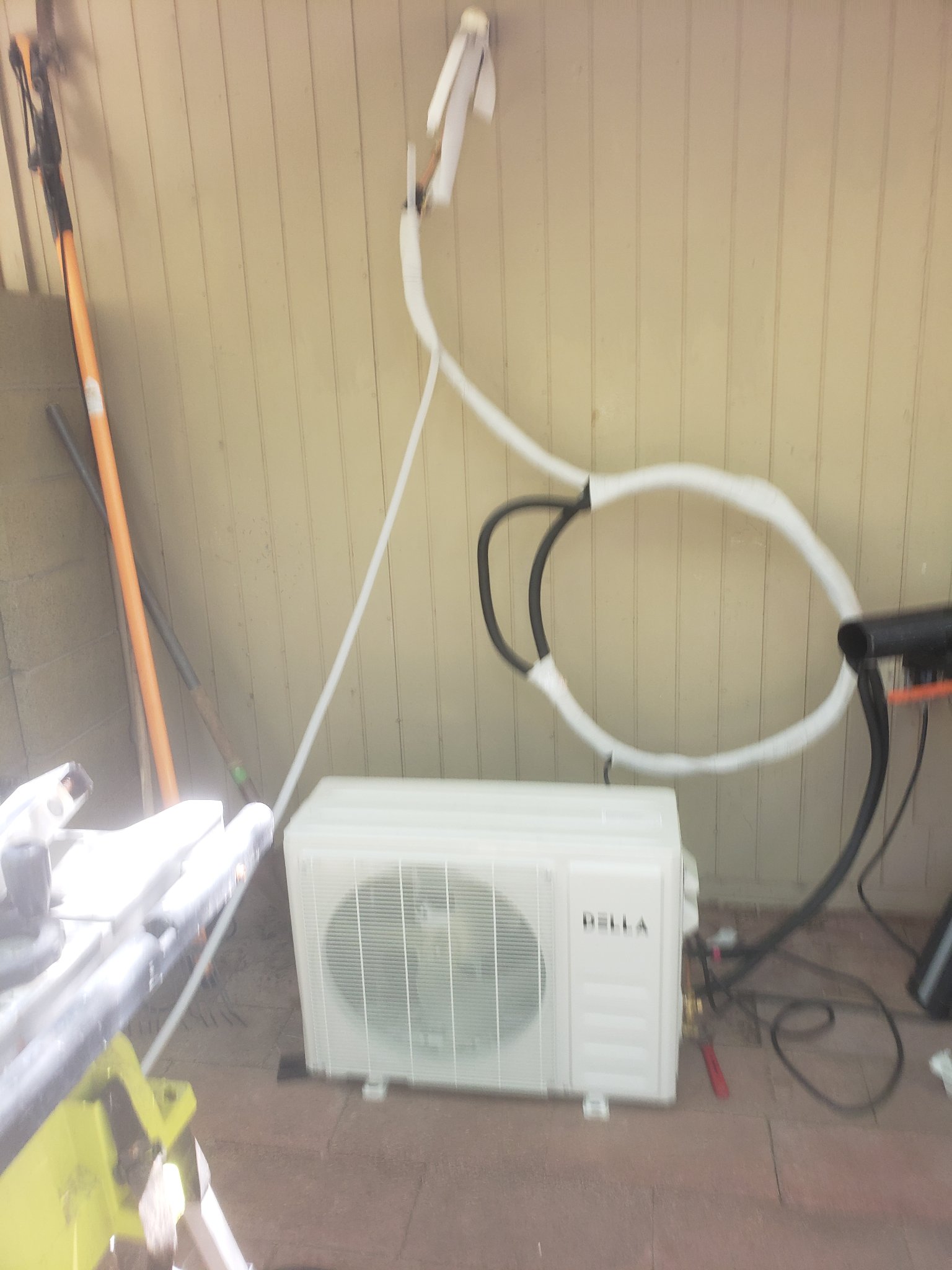 Before reinstall — messy line set, unit sitting on ground