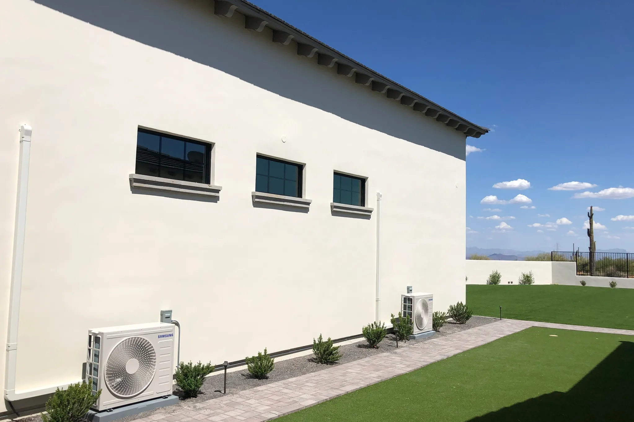 Two Samsung mini split outdoor units installed on side of large RV garage — Arizona